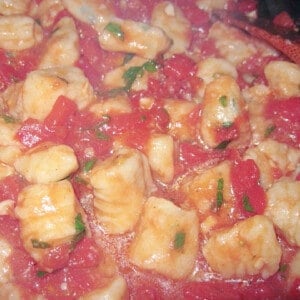 A closeup photo of Ricotta Gnocchi in a tomato sauce.