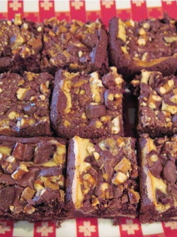 A red and white platter filled with squares of Cream Cheese Brownies.