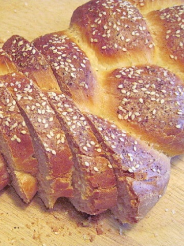 A sliced loaf of braided James Beard County Fair Bread with sesame seeds on top.