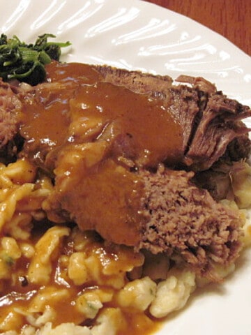 A serving of Slow Cooker Sauerbraten on a white dinner plate.