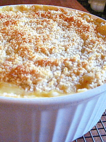 A round white casserole dish filled with Sweet and Cheesy Onion Casserole with a crunchy topping.