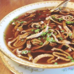 A serving of German Pancake Soup in a pretty china bowl.