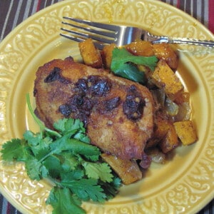 A serving of Chipotle Honey Chicken on a yellow plate with cilantro and a fork.