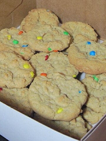A white bakery box filled with M & M Oatmeal Cookies.