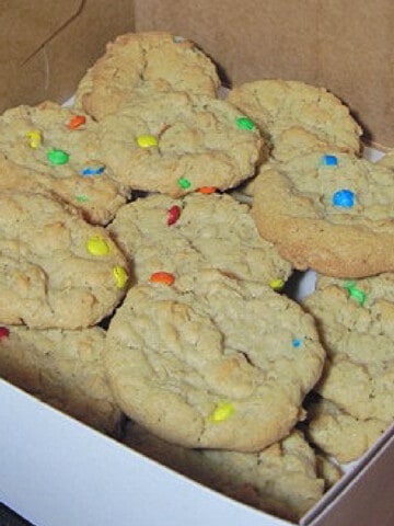 A white bakery box filled with M & M Oatmeal Cookies.