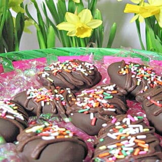 A basket filled with Chocolate Peanut Butter Eggs with daffodils in the background.