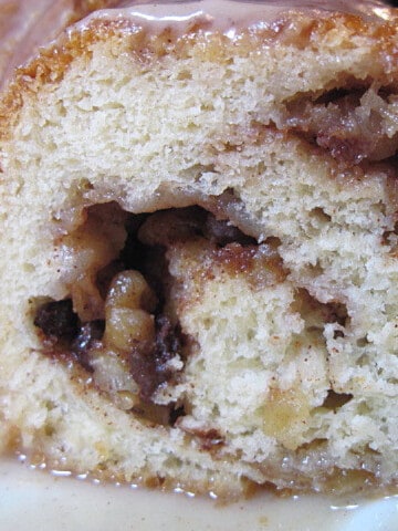 A slice of a Cinnamon Roll Cake with apples and walnuts.