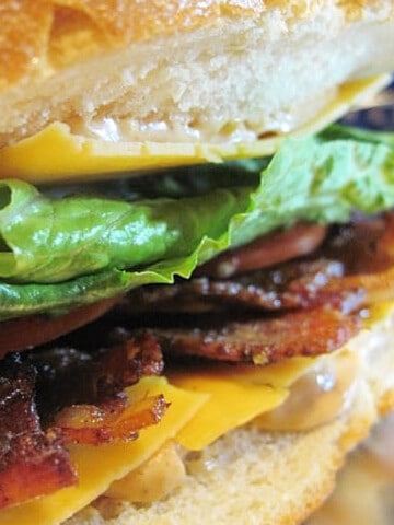 A closeup of the inside of a BLT with Smoky Bacon, lettuce, cheese, and tomato.