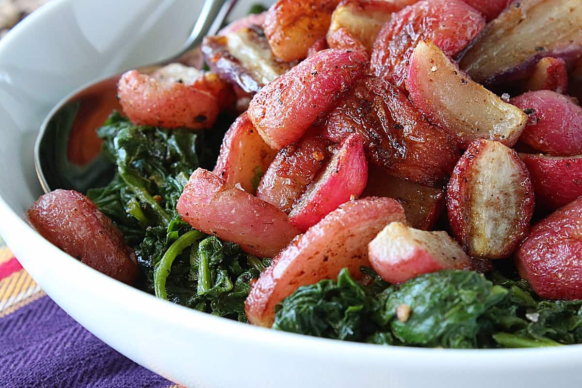 Red Roasted Radishes in a bowl with a spoon.