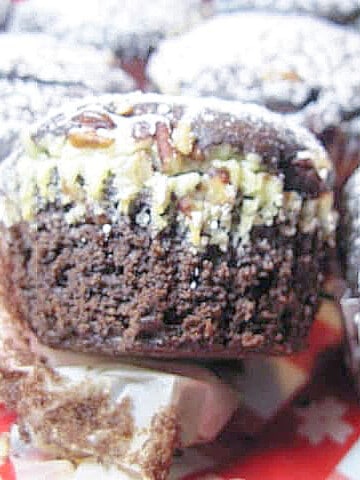 The sideview of a Chocolate Cheesecake Cupcake with pecans.