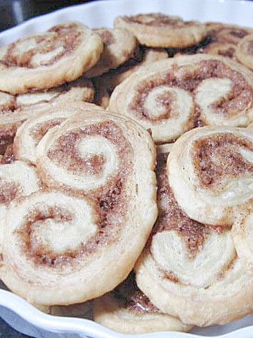 A bunch of Orange Cinnamon Palmiers in a white dish.