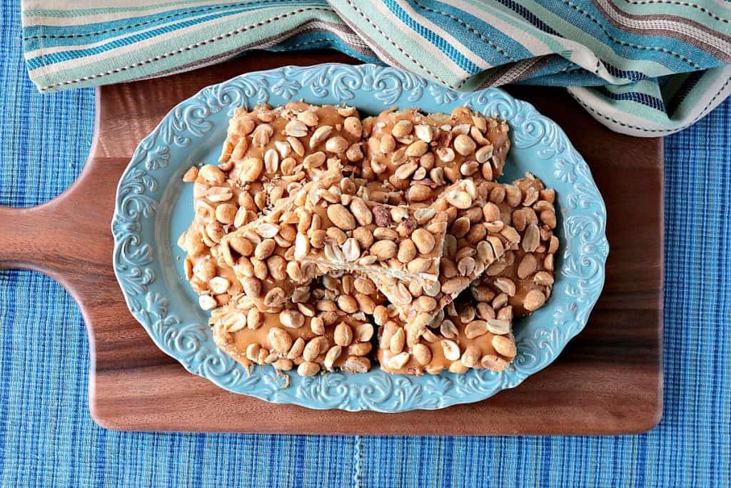 Overhead picture of a plate of copycat payday candy bars on a blue plate and wood board. - kudoskitchenbyrenee.com