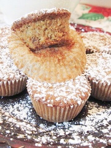 Little Nut Cup Cookies on a red plate with a dusting of powdered sugar.