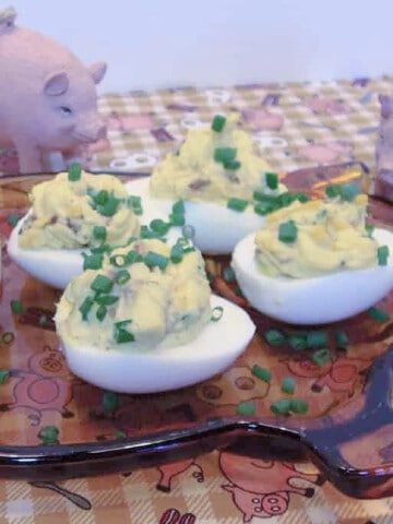 Four Angelic Deviled Eggs on a glass pig plate.