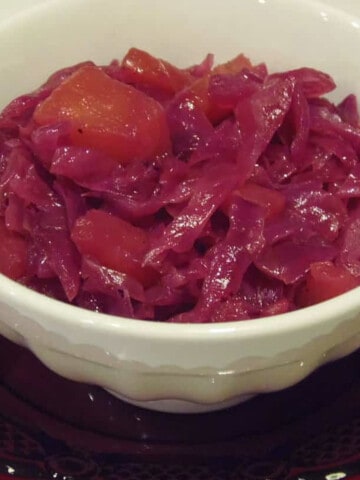 A small round white bowl filled with Sauteed Rid Cabbage with Pineapple.