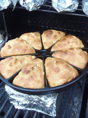 A divided cast iron skillet on the grill filled with golden brown Cast Iron Skillet Cornbread.