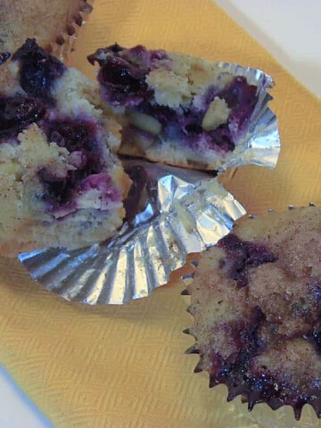 A few Banana Blueberry Muffins with Lemon on a yellow napkin.