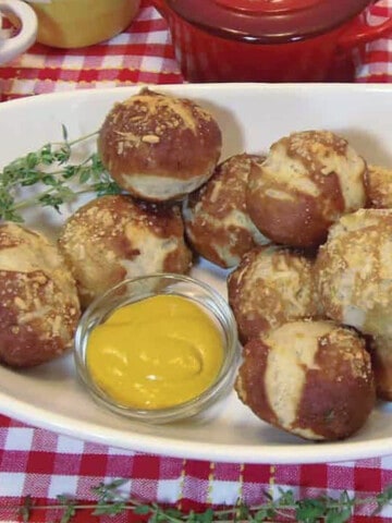 A white oval bowl filled with Garlic Thyme Pretzel Bites.