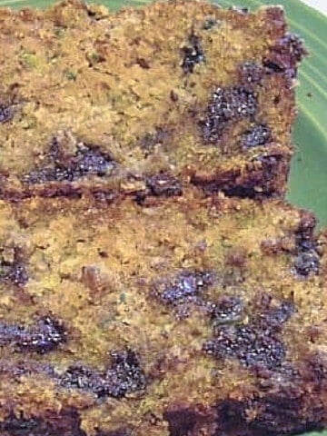 Two slices of Chocolate Chip Zucchini Bread on a green plate.