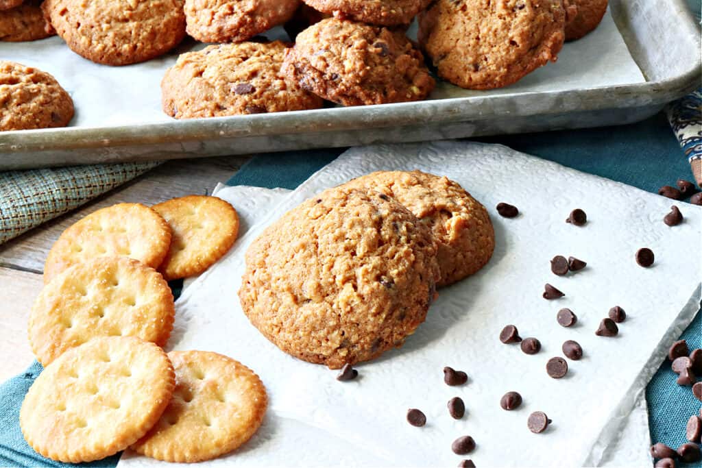 A couple of Butterscotch Ritz Cookies on a white napkin along with some Ritz cracker and some chocolate chips.