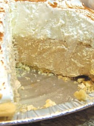 A White Chocolate Cinnamon Silk Pie with a slice taken out.