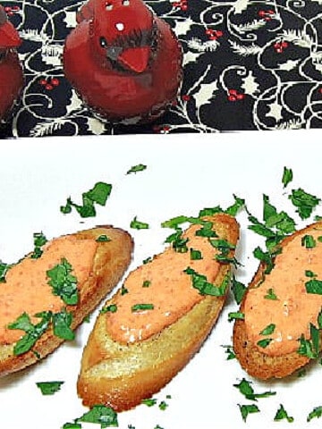 Garlic Toast with Red Pepper Aioli on a white plate topped with fresh parsley.