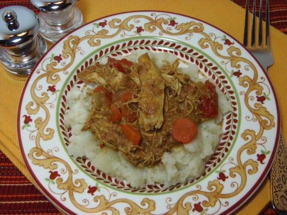 A colorful dinner plate filled with a serving of Coconut Chicken Curry with carrots.