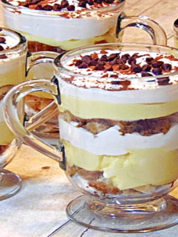 Four Skinny Tiramisu Parfaits in Irish coffee mugs with chocolate chips and whipped cream.