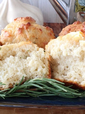 The inside of a Garlic Rosemary Focaccia Muffin on a plate with rosemary.