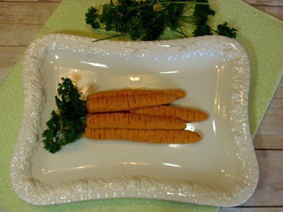 A bunch of Cheesy Carrot Appetizers on a white platter with fresh parsley.