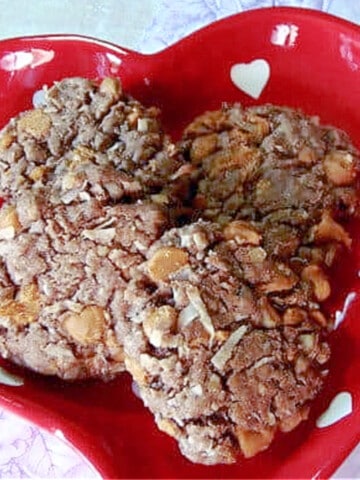 A red and white heart dish filled with four German Chocolate Cookies.