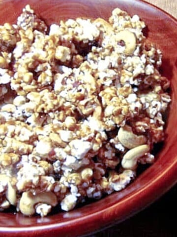 A brown wooden bowl filled with Cashew Bacon Caramel Corn.