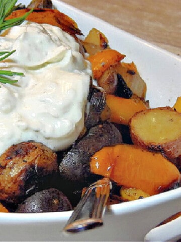 A white dish filled with Colorful New Potatoes with peppers and sour cream.