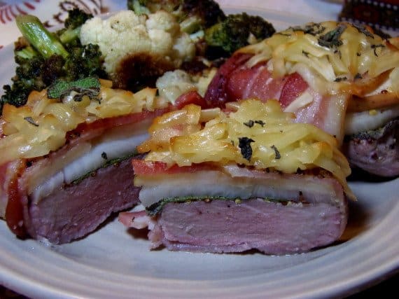 A serving of Pork Tenderloin Stacks wrapped with bacon and topped with grated cheese.