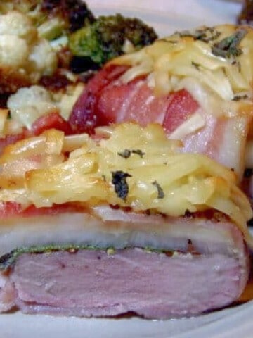 A serving of Pork Tenderloin Stacks wrapped with bacon and topped with grated cheese.