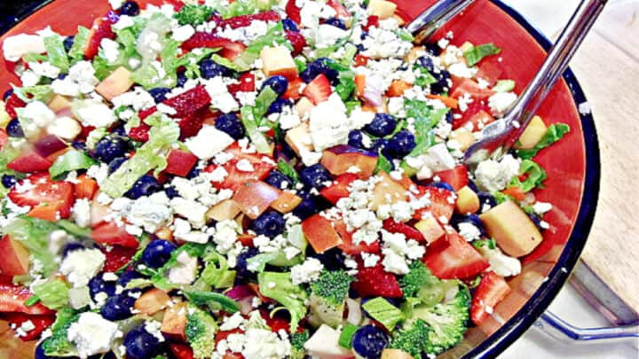 A colorful Summertime Chopped Salad with blueberries, romaine, strawberries, and blue cheese.