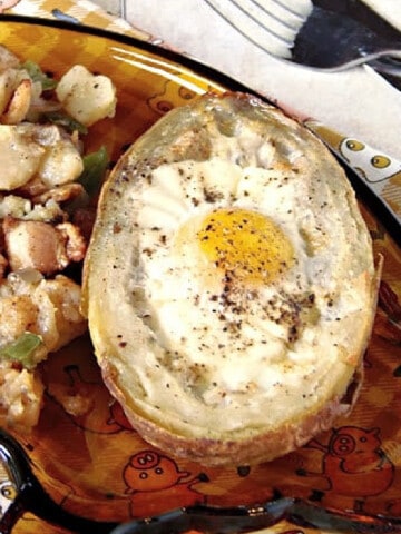 A photo of Eggs in Potato Boats with hash brown potatoes on the side.