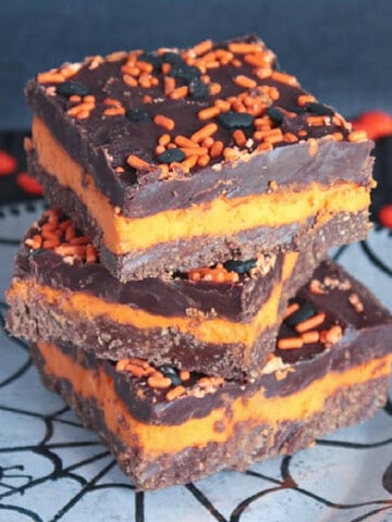 Three No-Bake Chocolate Mint Bars stacked on a plate.