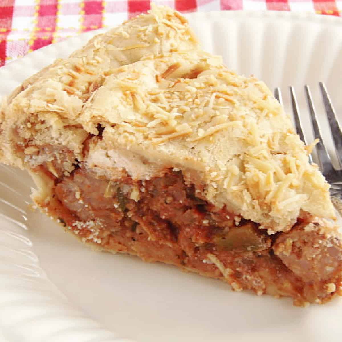 A slice of Pizza Pie on a white plate with a fork.