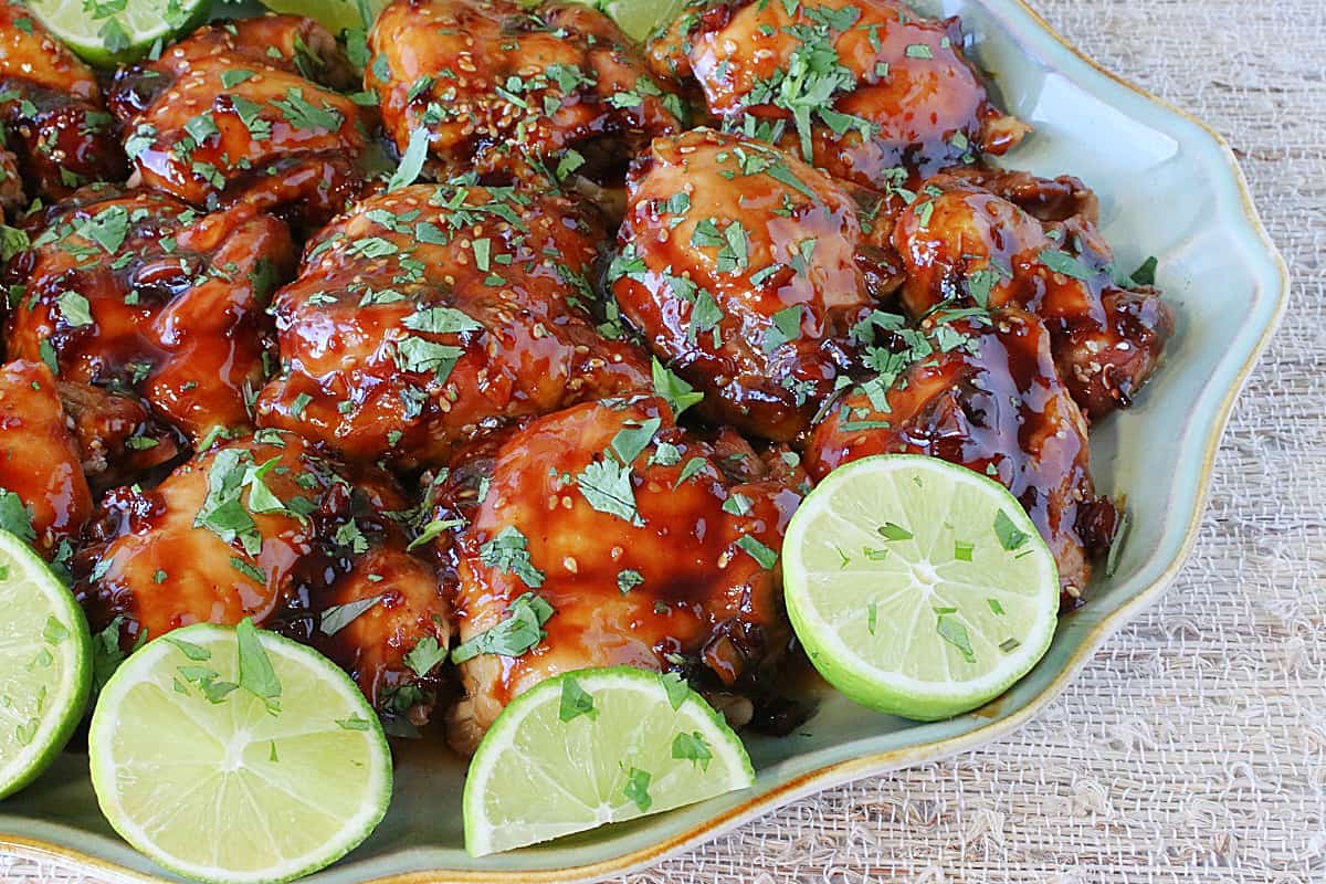 Fresh limes on a platter of Teriyaki Glazed Chicken Thighs.