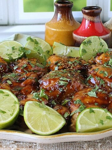 A platter filled with Teriyaki Glazed Chicken Thighs and cilantro.