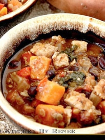 A serving of Chicken and Sweet Potato Stew in a brown bowl with beans.