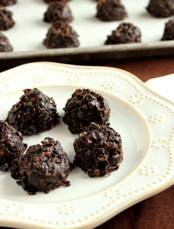 A white plate filled with 5 No Bake Chocolate Peanut Butter Cookies with a baking sheet in the background.