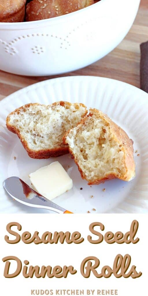 A Sesame Seed Dinner Roll on a white plate with a bowl filled with rolls are in the background.