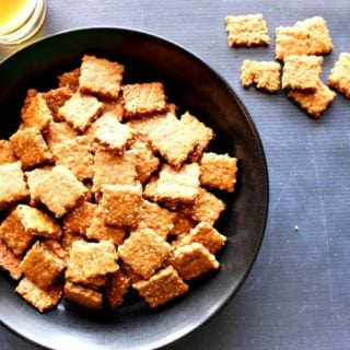 Overhead photo of a black bowl filled with homemade honey sesame seed crackers
