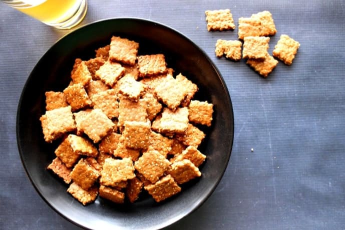 Overhead photo of a black bowl filled with homemade honey sesame seed crackers