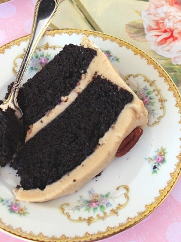 A slice of Chocolate Layer Cake with Caramel Frosting on a pretty plate.