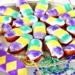 A platter filled with Mini Long Johns along with mardi gras beads and a mask.