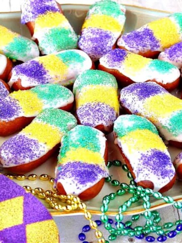 A platter filled with Mini Long Johns along with mardi gras beads and a mask.