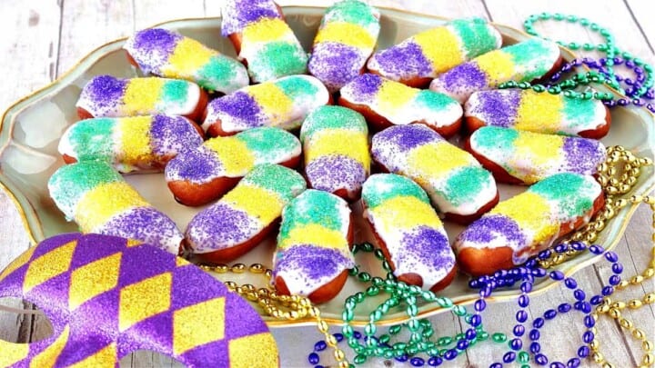 A platter filled with Mini Long Johns along with mardi gras beads and a mask.